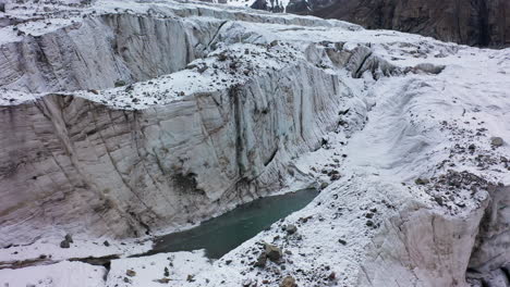 Rotierende-Aufschlussreiche-Drohnenaufnahme-Einer-Großen-Öffnung-Und-Schlucht-Im-Ak-Sai-Gletscher-In-Kirgisistan