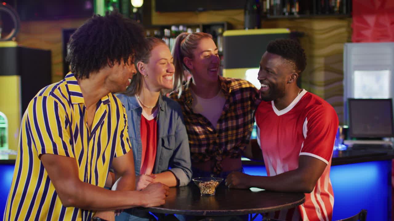 video de un grupo diverso de amigos felices de pie en una mesa