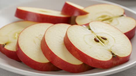 freshly sliced red apples showcasing their crisp, juicy flesh in a serene arrangement on a white plate, perfect for healthy snacking and culinary inspiration