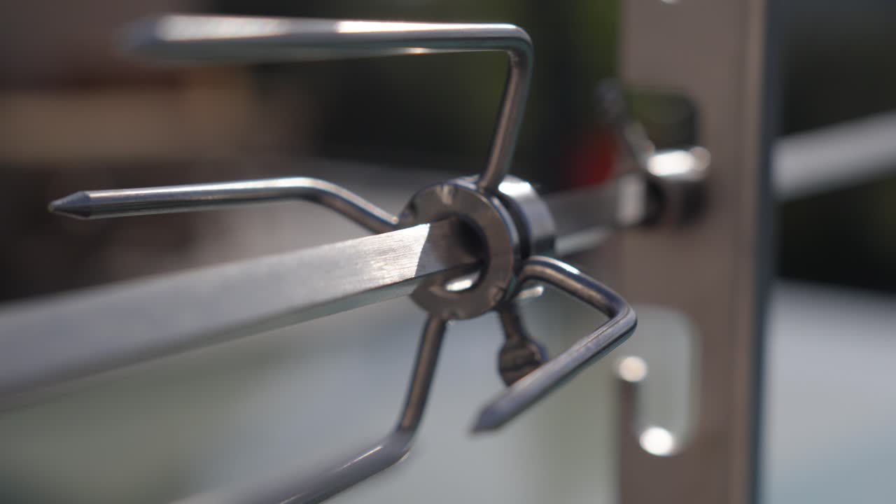 close-up of a metal kebab skewers sitting empty ontop of a barbecue