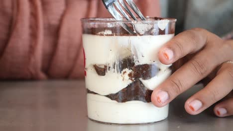 una persona disfrutando de una deliciosa rebanada de tiramisu