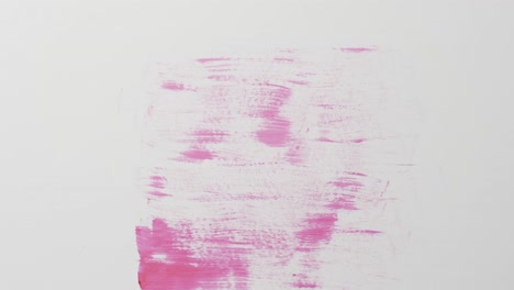 Close-up-of-pink-paint-shapes-on-white-background-with-copy-space,-slow-motion