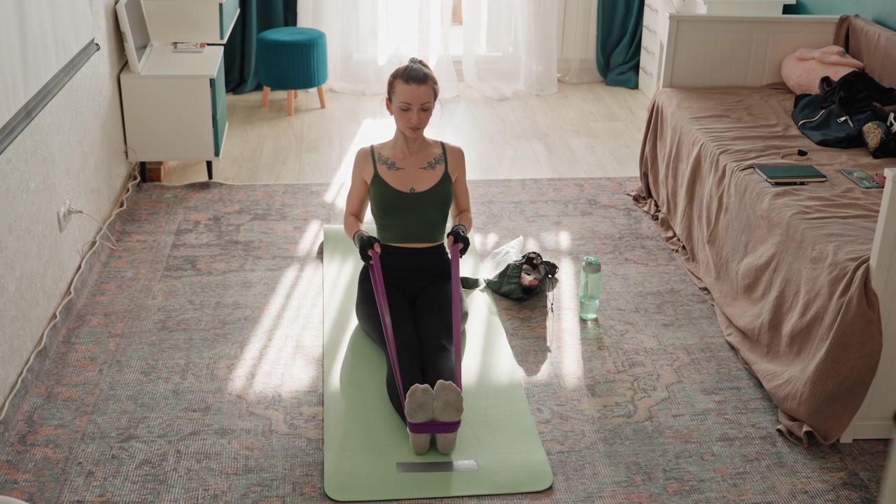 Woman performing full body resistance band routine on rug, centerframed mat near bed, steady cadence, online coach mode, athlete training vibe, core engagement, balance and conditioning focus