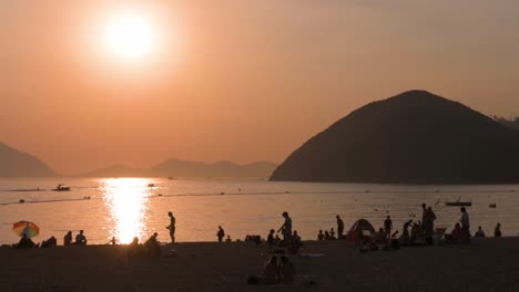 menschen genießen den abend am repulse bay beach in hongkong, während die öffentlichen strände nach monatelanger schließung aufgrund des coronavirus-ausbruchs wieder für die öffentlichkeit geöffnet werden