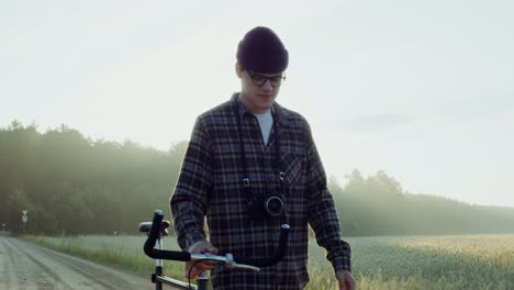 man with a bicycle and camera at sunrise