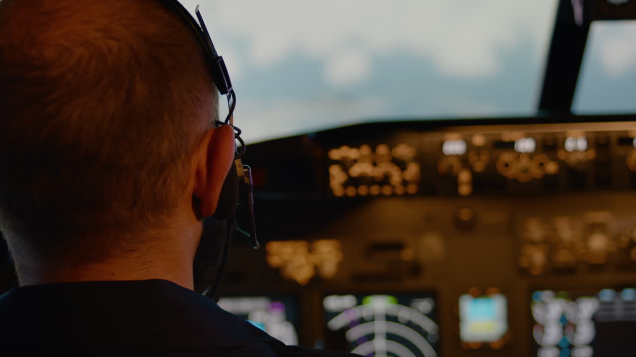 Male aviator using handle and windscreen in cockpit to fly airplane