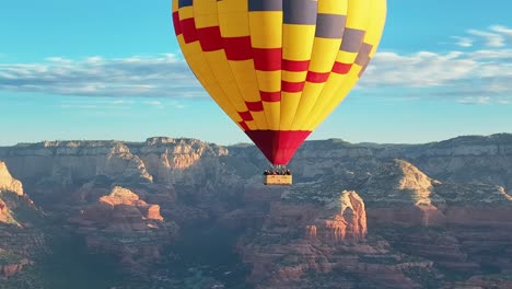 picturesque view of a colorful hot air balloon ascending at high altitude during daytime in sedona, arizona, united states