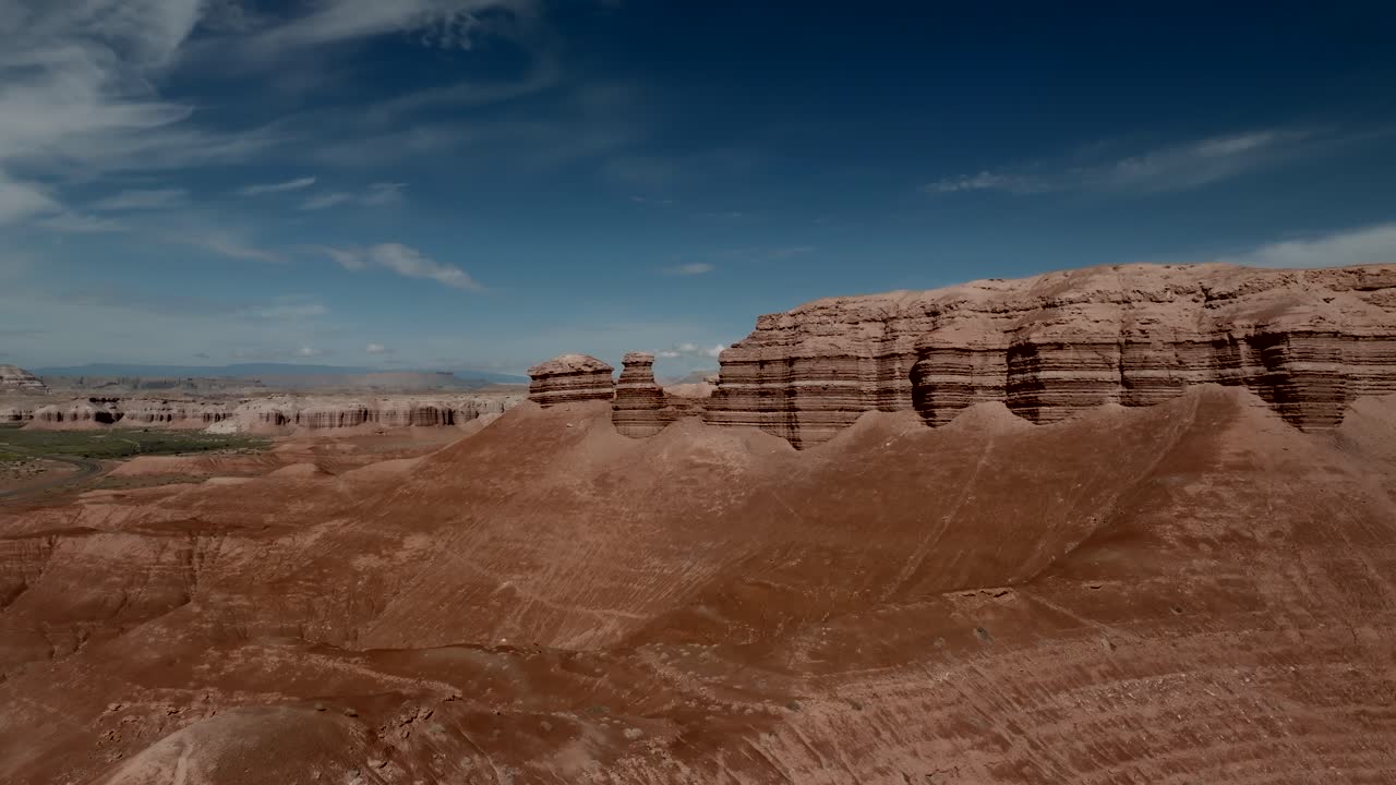 Red cliff sandstone butte in Utah's Caineville Desert - aerial forward