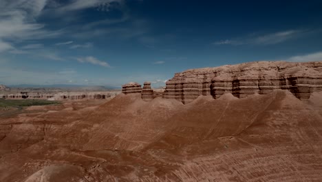 Acantilado-De-Arenisca-Roja-En-El-Desierto-De-Caineville-En-Utah---Avance-Aéreo