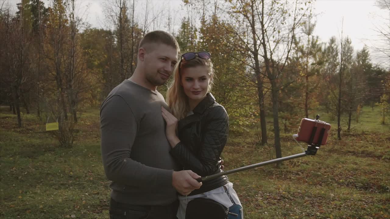 пара делает селфи в осеннем парке.