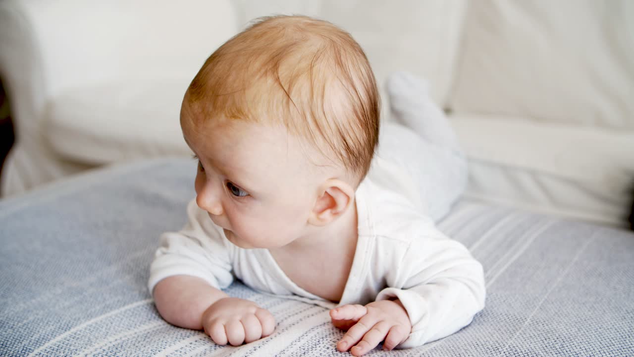 Tankefull, søt blåøyd baby som ser seg rundt