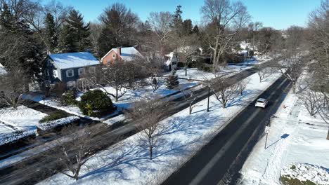 Driving-cars-on-road-in-american-town-at-winter-snow-day