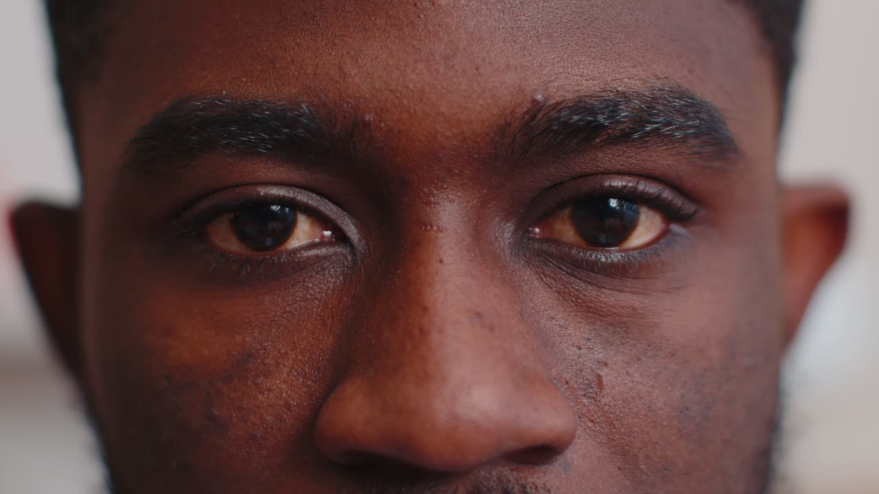 Closeup macro portrait of beauty young african american mans eyes smiling model looking at camera