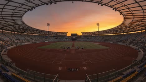a dramatic transition in time: capturing the beauty of a stadium at sunset, from vibrant hues to subdued tones in a serene atmosphere