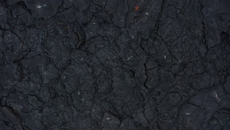 dark black basalt rock solidified lava field cracked rugged surface