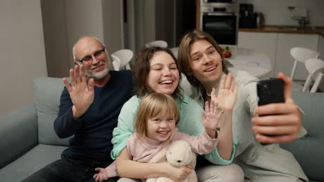 abuelo y nietos se están divirtiendo haciendo selfies o videollamadas a la familia con el teléfono inteligente