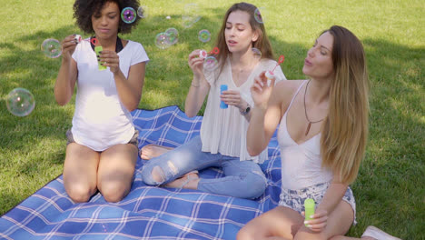 young women blowing bubbles