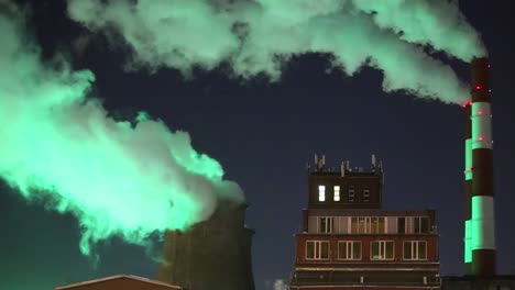 green smoke from chimney of night industrial cityscape with carbon emissions from factory