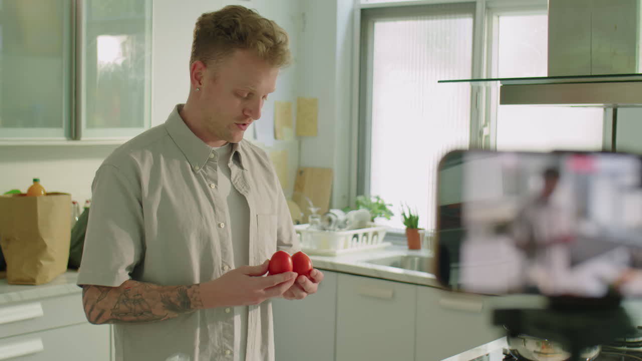 Man Filming Cooking Vlog in Kitchen with Smartphone
