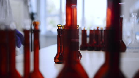 a scientist takes a brown bottle in the laboratory and puts it into further research