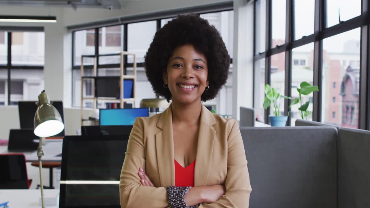 retrato de una mujer de negocios de raza mixta sentada mirando a la cámara y sonriendo en la oficina