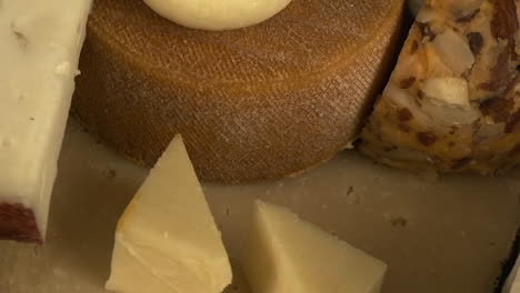 macro narrow focus closeup view of various cheeses on plate rotating