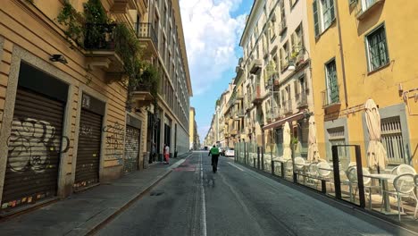 cyclist rides through a quiet turin street