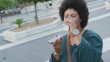 mujer bi-racial feliz de talla plus hablando por teléfono inteligente en la ciudad
