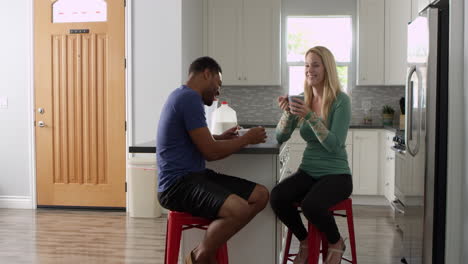 Mixed-race-couple-talking-over-breakfast-in-the-kitchen,-shot-on-R3D