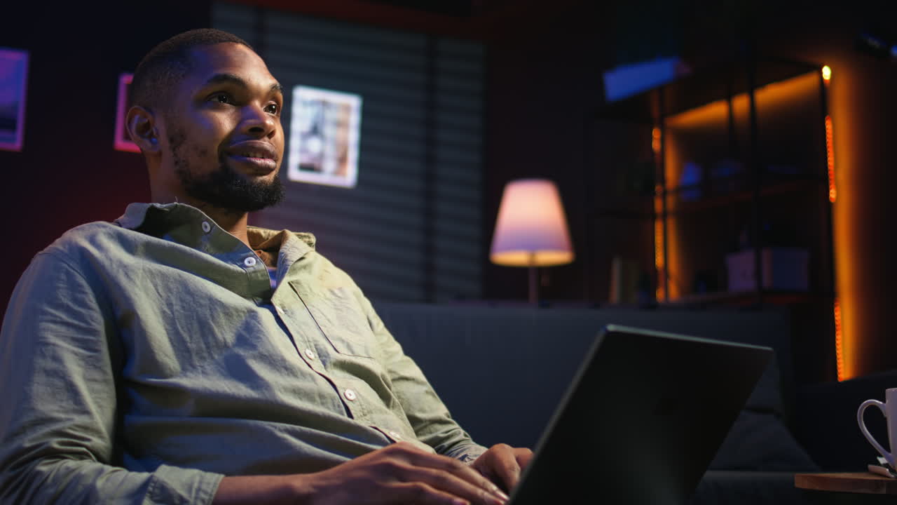 Vertical Video Portrait of african american adult typing data on his laptop at home