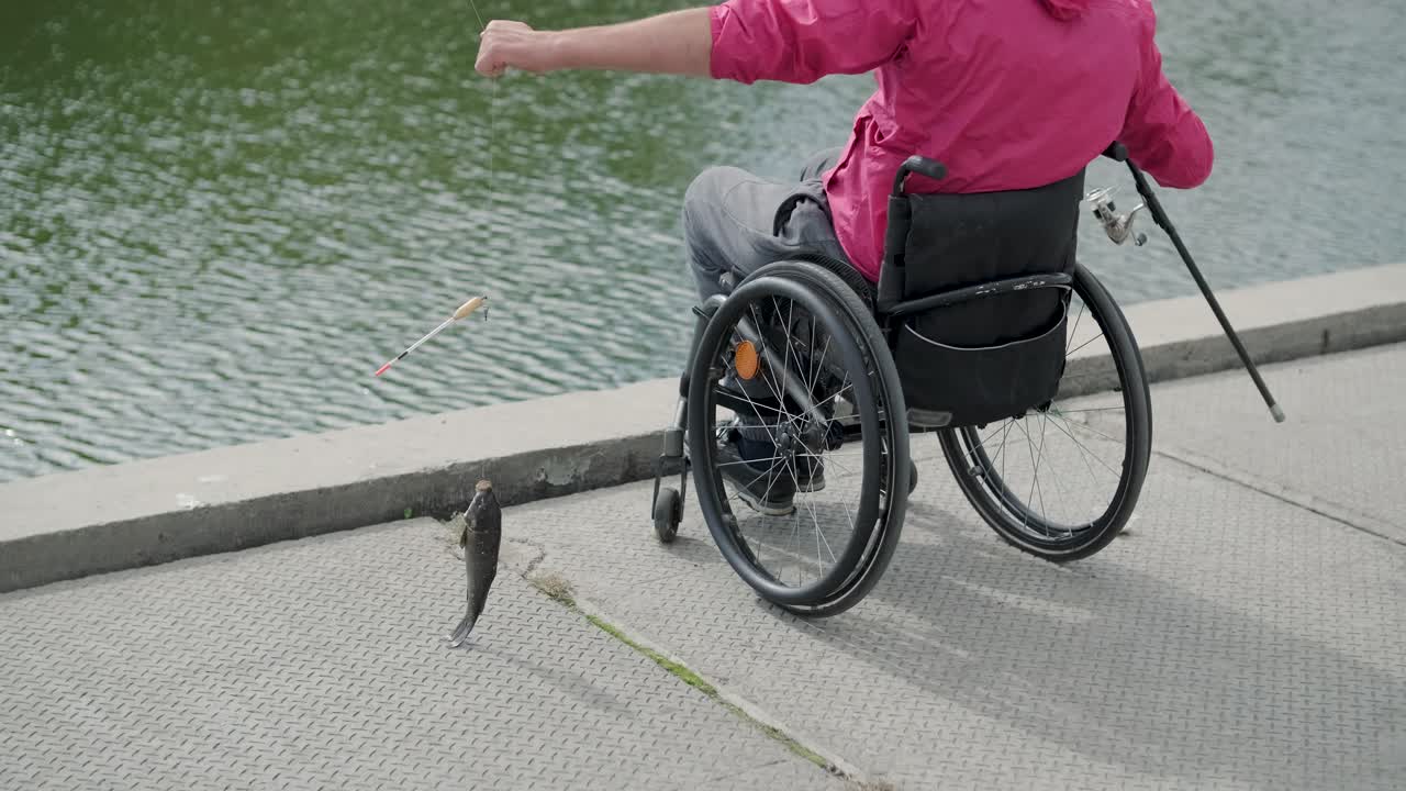 persona con discapacidad física que utiliza silla de ruedas para pescar en el muelle de pesca