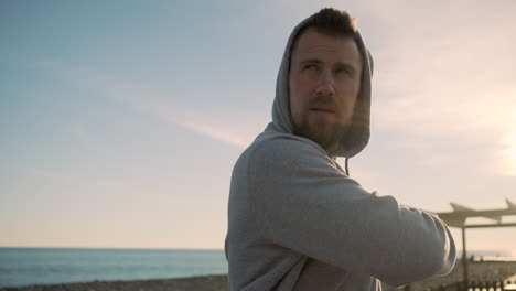 man stretching on the beach at sunset