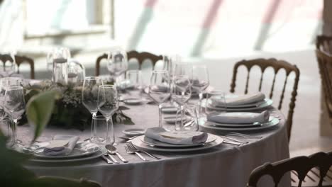 sophisticated wedding table arrangement with glassware, floral centerpiece, and golden chairs