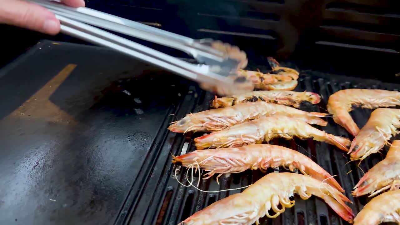 camarones siendo asados con pinzas en la barbacoa