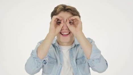 young man searching with handmade binocular on white background