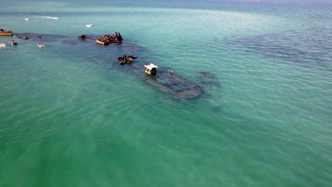 aerial orbit above historic tangalooma wrecks, vibrant marine life, turquoise waters, and sandy shallow coves