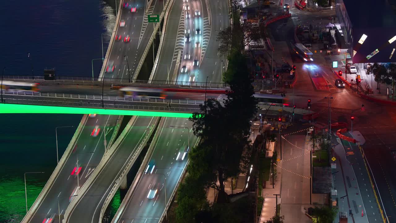 el time-lapse nocturno captura el tráfico ocupado en la autopista de la orilla del río, los autobuses que corren por el puente iluminado de victoria