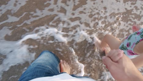 Vista-Aérea-Del-Padre-Sosteniendo-La-Mano-De-La-Niña-Mientras-Camina-Por-La-Playa