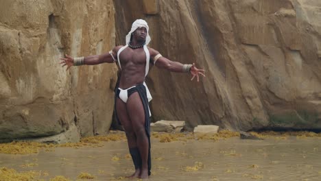 a beach is the setting for this muscular, dark-skinned male cosplayer.