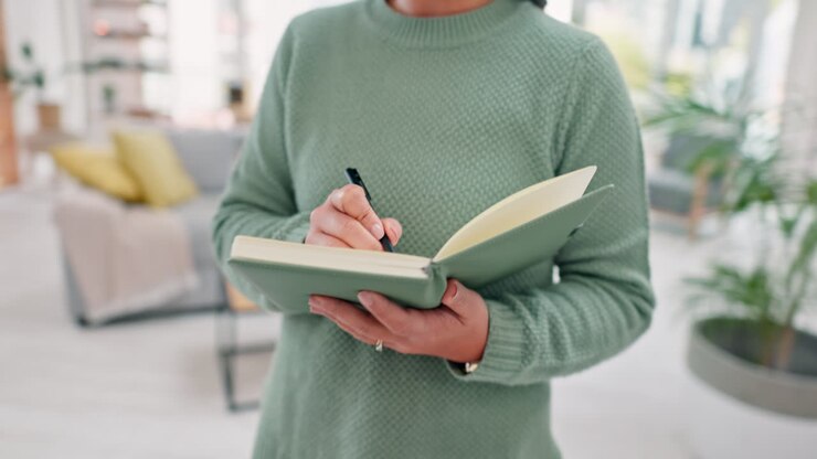 Woman, writing in notebook and remote work
