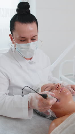 cosmetólogo haciendo el procedimiento de peeling mujer regeneración de la piel dermapen microneedling dermastamp