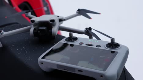 close-up of a drone and its controller in a snowy environment