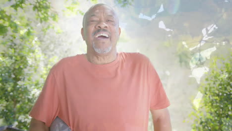 Animation-of-spots-of-light-and-trees-over-smiling-senior-african-american-man-in-garden