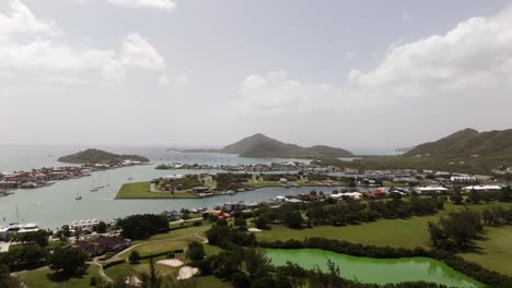 jolly harbor antigua coastal view with marinas, boats, green landscapes, and hills on a cloudy day