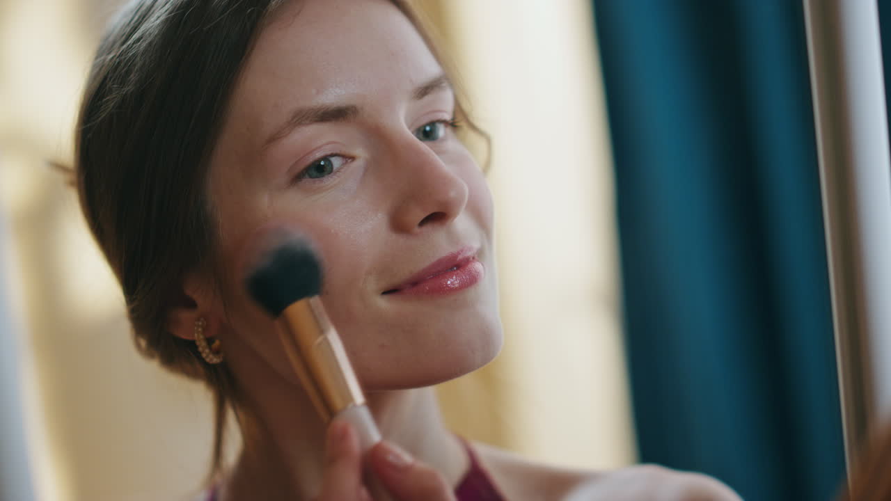 매력적인 여성이 거울에 메이크업을 하고 있다. 반사 클로즈업. 행복한 소녀 신청