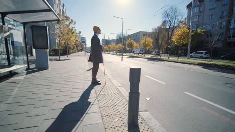 blinded man waiting for bus at a bus station