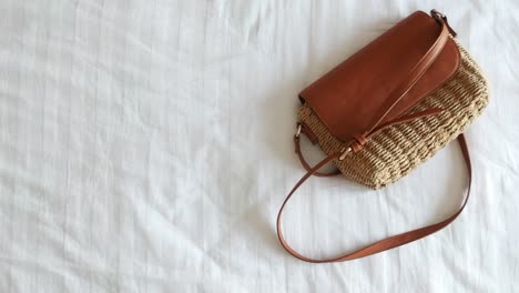 brown straw shoulder bag and phone