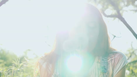 a girl with bright red hair has fun playing with dandelion flowers 1