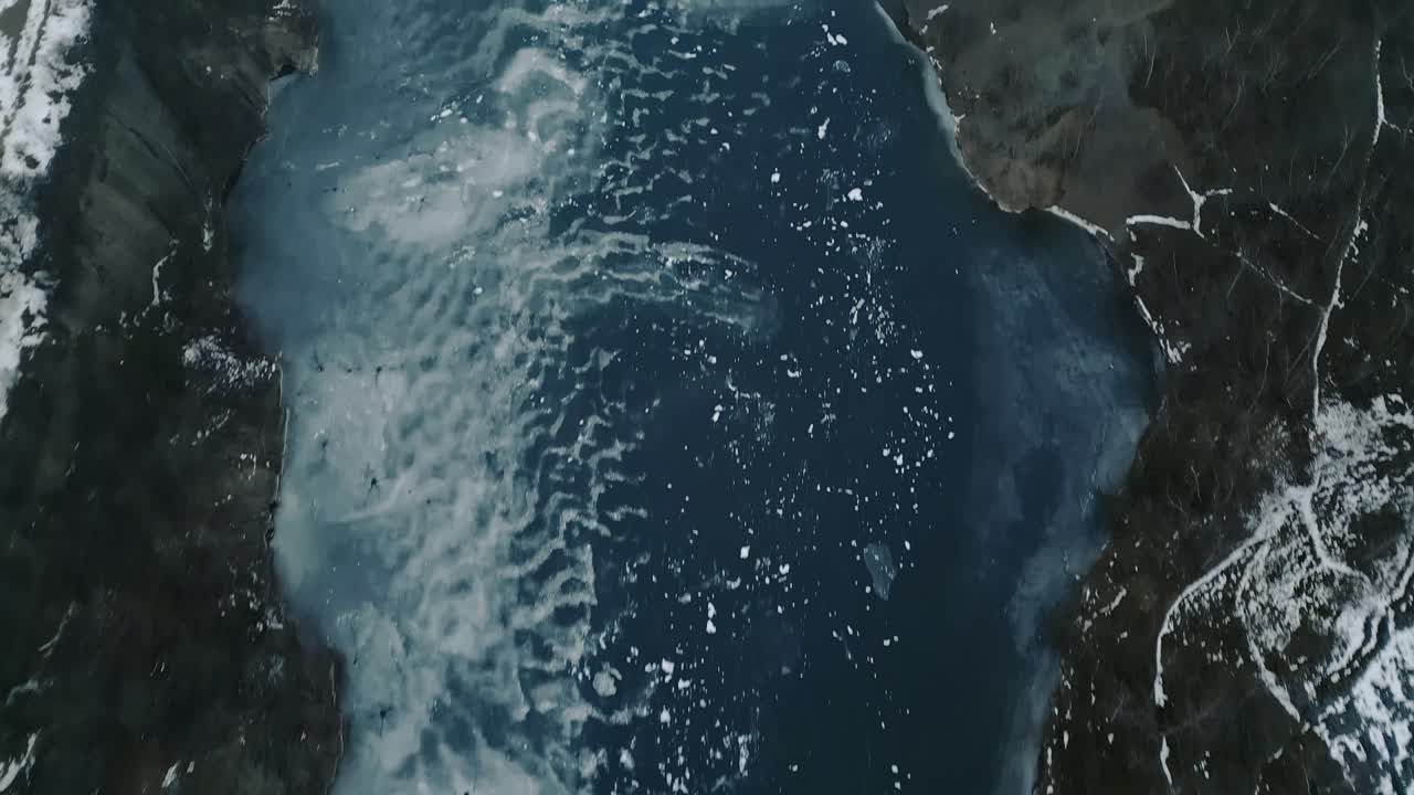 Drone top down over frozen flooded abandoned slate quarry.Ideal for documentary, winter environment, and mining history visuals