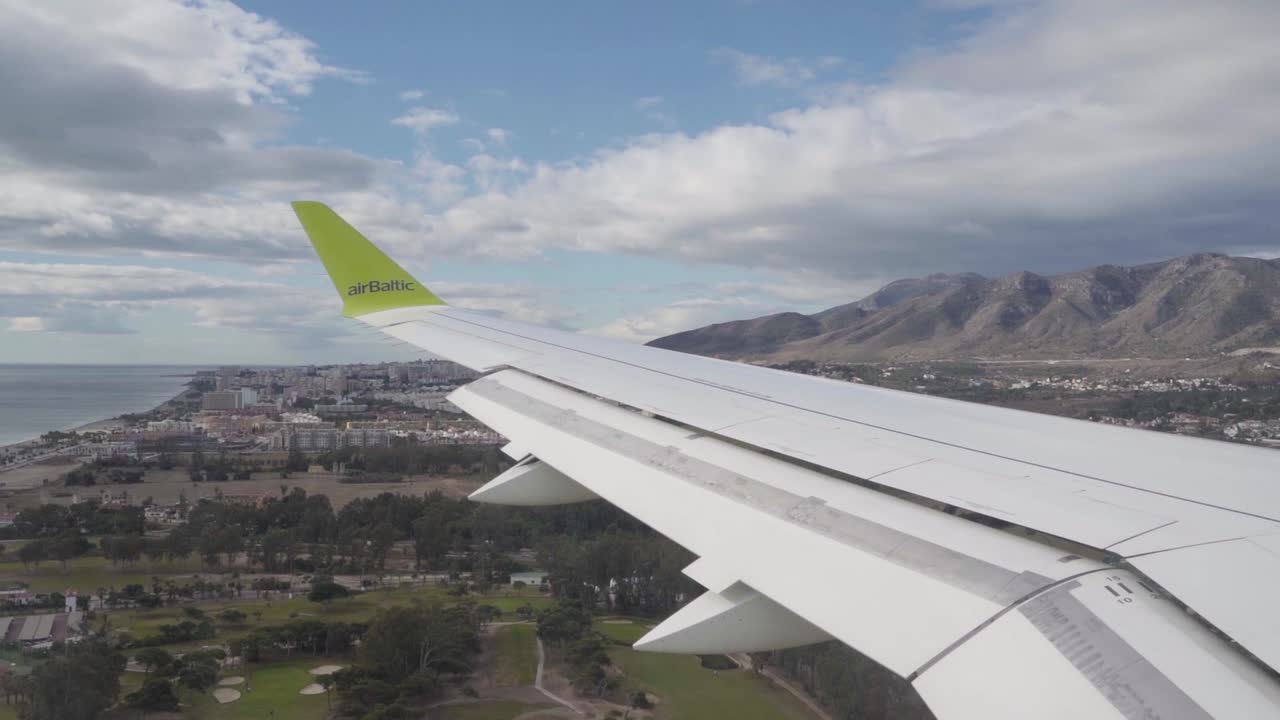 Air Baltic plane flying over the coast upon arriving at Malaga, Spain.